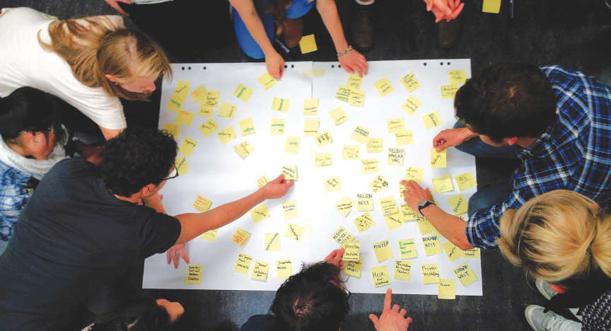 Studenten arbeiten mit Post-Its, um ihre Ideen auf Papier zu bringen. Foto: Andreas Lauenroth