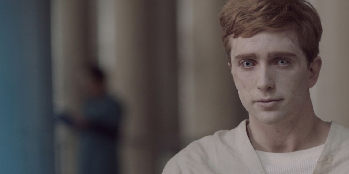 Jugendlicher mit fahler Haut, Zombieaugen und hellem Krankenhauskittel