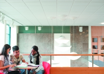 Drei internationale Studierende schauen sich gemeinsam ein Buch an