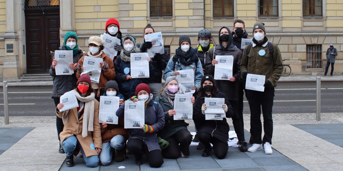 Die Mitglieder der Hochschulzeitung stehen vor dem Landgericht. Sie haben die Ausgabe in den Händen, in der der Artikel abgedruckt ist.