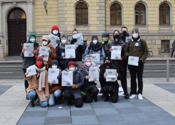 Die Mitglieder der Hochschulzeitung stehen vor dem Landgericht. Sie haben die Ausgabe in den Händen, in der der Artikel abgedruckt ist.